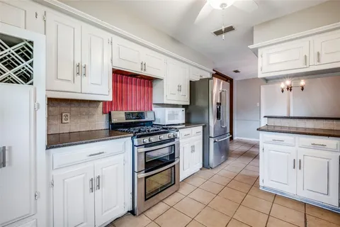 a kitchen with stainless steel appliances granite countertop a stove a sink and a refrigerator