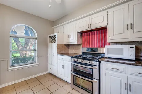 a kitchen with stainless steel appliances granite countertop a stove and cabinets