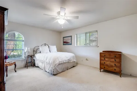 a spacious bedroom with a bed and a dresser