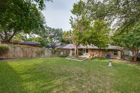 a view of a house with a big yard and sitting area