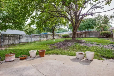 a view of a backyard with furniture and garden