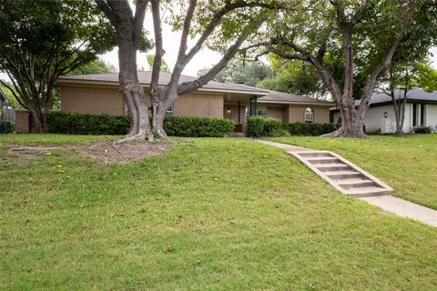 a front view of a house with a yard and trees