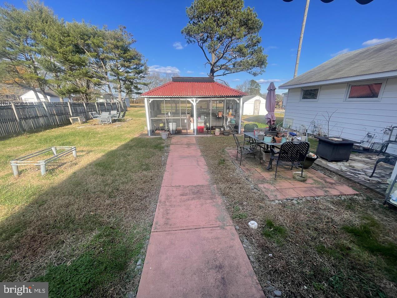 202 Gumboro Road Selbyville, DE 19975 - Photo 19 of 22 a view of a patio with a table and chairs under an umbrella