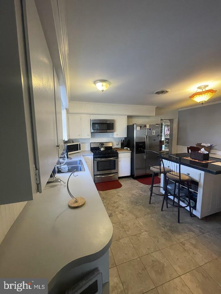 202 Gumboro Road Selbyville, DE 19975 - Photo 4 of 22 a kitchen with stainless steel appliances granite countertop a sink a stove counter space and chairs
