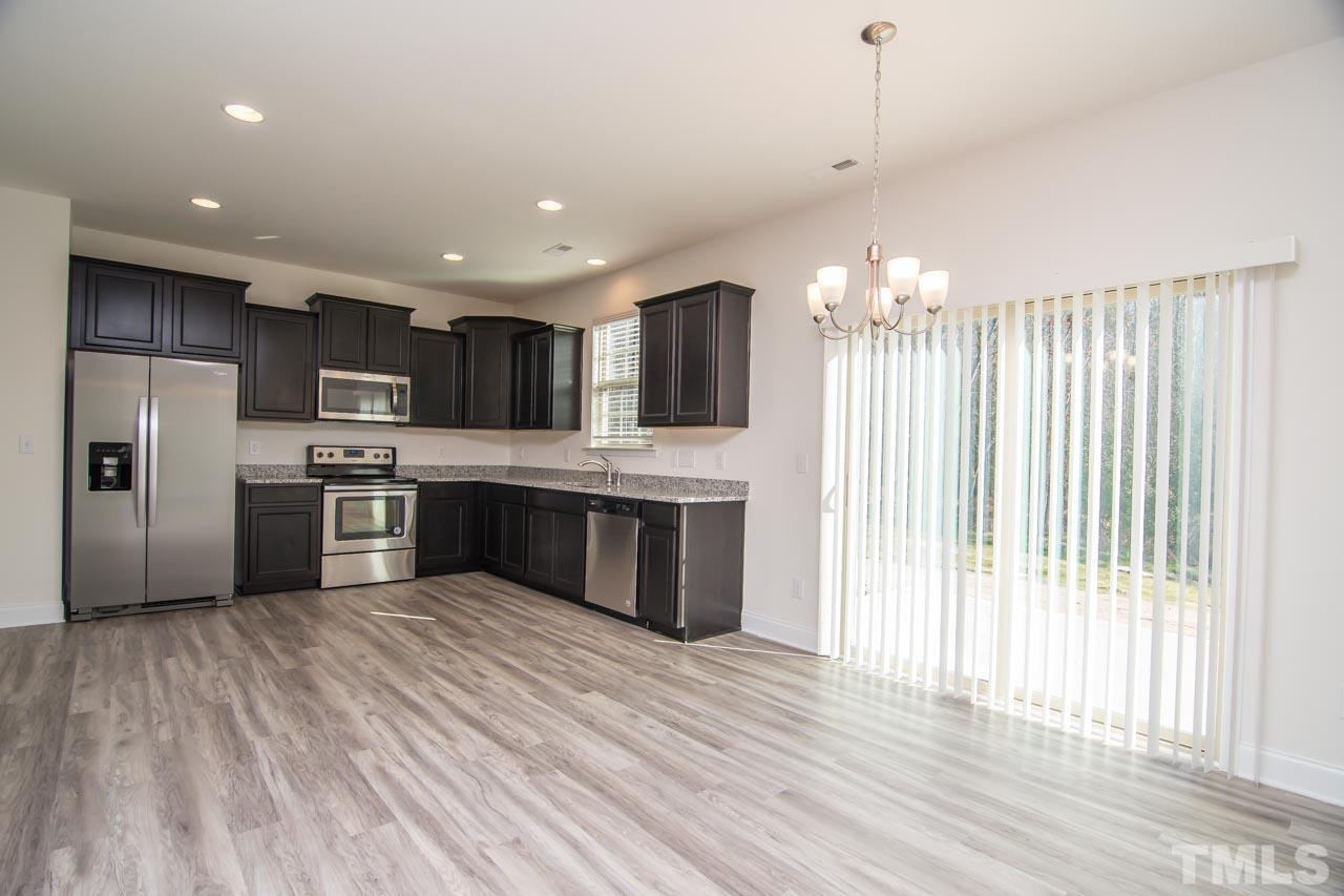 4531 Lord Mario Court Raleigh, NC 27610 - Photo 1 of 27 a large kitchen with kitchen island a island wooden floors stainless steel appliances and cabinets