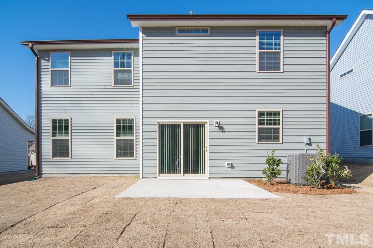 4531 Lord Mario Court Raleigh, NC 27610 - Photo 27 of 27 a backyard of a house with potted plants and a garage