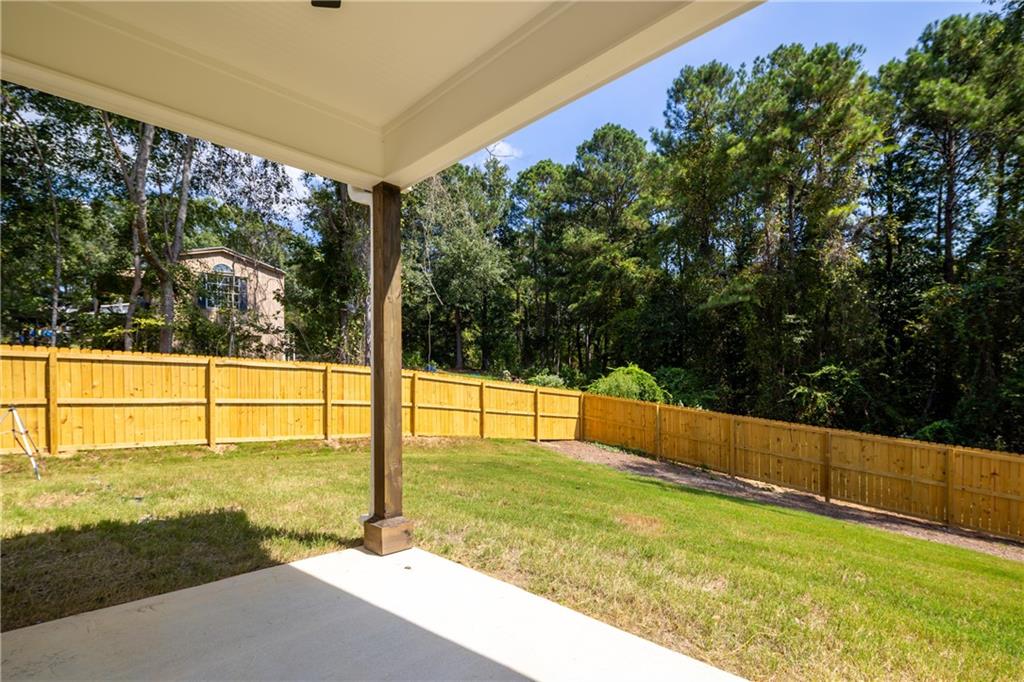 111 Lee Road Phenix City, AL 36867 - Photo 3 of 23 Covered patio with a substantial support column, concrete flooring, and an expansive fenced backyard
