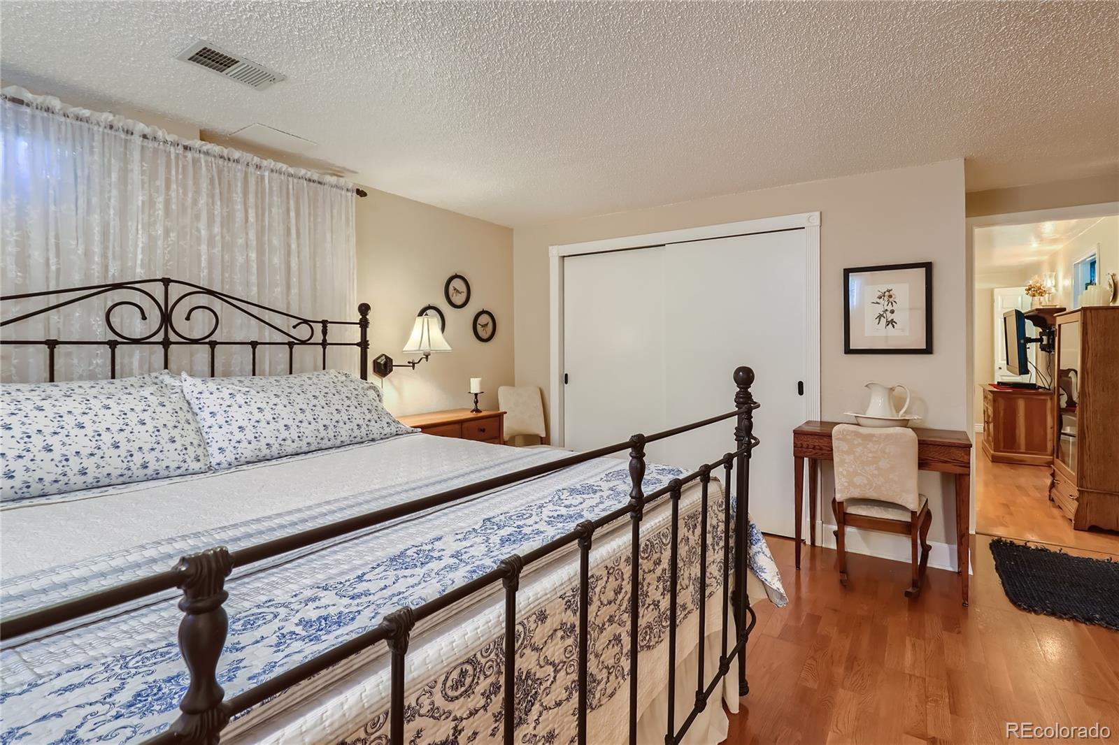 5366 Field Circle Arvada, CO 80002 - Photo 18 of 28 a bedroom with furniture and wooden floor