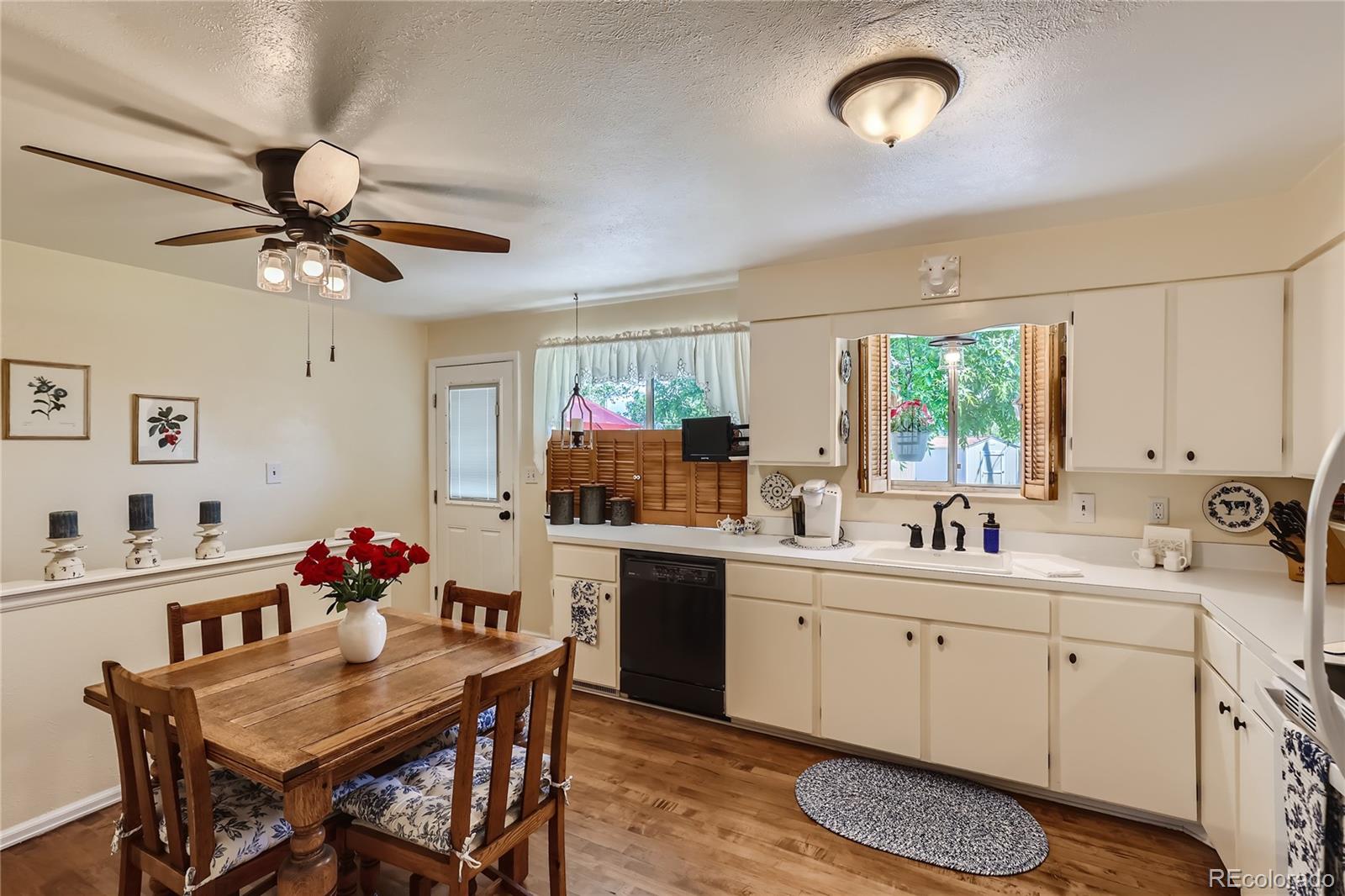 5366 Field Circle Arvada, CO 80002 - Photo 9 of 28 a kitchen with a sink cabinets a stove a dining table and chairs