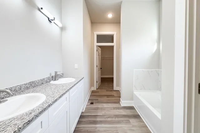 a bathroom with a granite countertop double vanity sink and a mirror