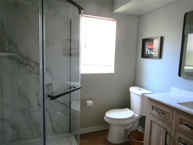 a white toilet sitting next to a bathroom sink and vanity