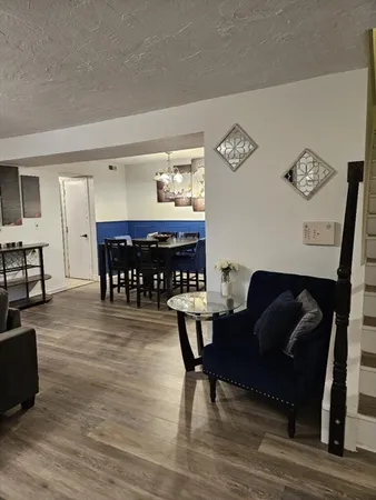 a living room with furniture and a dining table with kitchen view