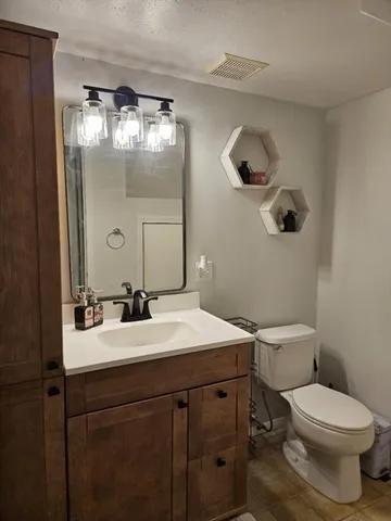 a bathroom with a sink vanity mirror and toilet