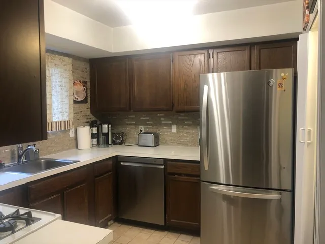 a kitchen with a refrigerator sink and cabinets