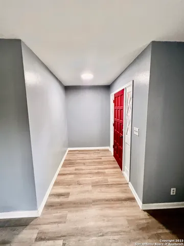 a view of a hallway with wooden floor and stairs