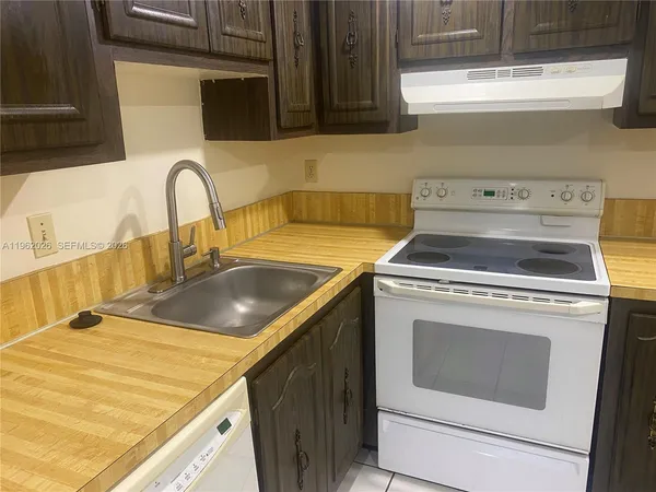 a kitchen with a sink stove top oven and cabinets