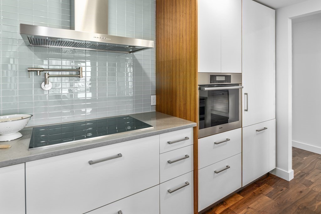 10 Rowes Wharf, Unit PH4 Boston, MA 02110 - Photo 25 of 41 a kitchen with granite countertop white cabinets and white appliances