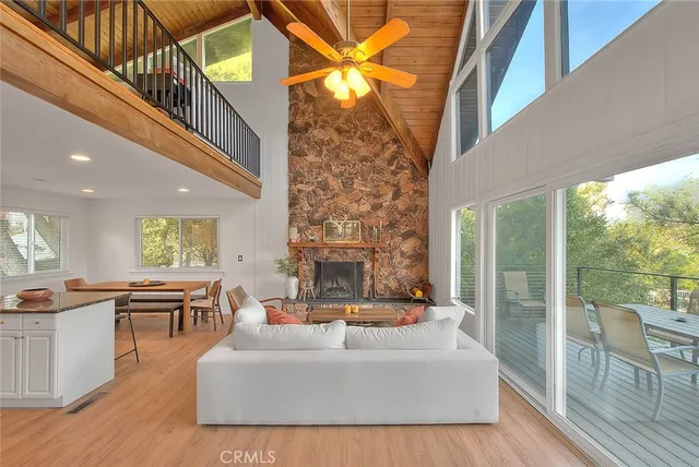 a living room with fireplace furniture and a large window