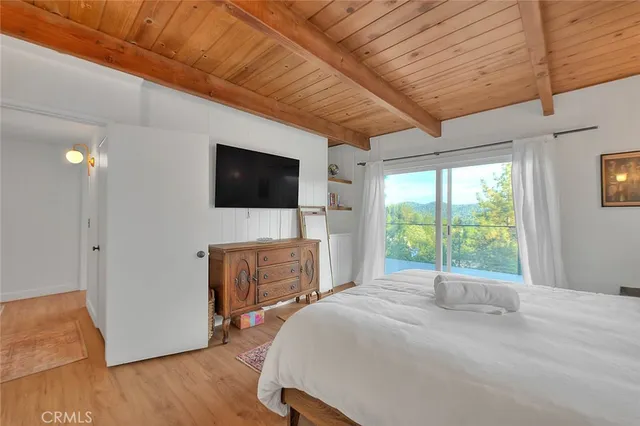 a bedroom with furniture and a flat screen tv