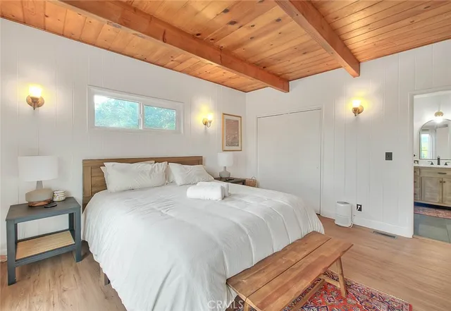 a bedroom with bed and wooden floor