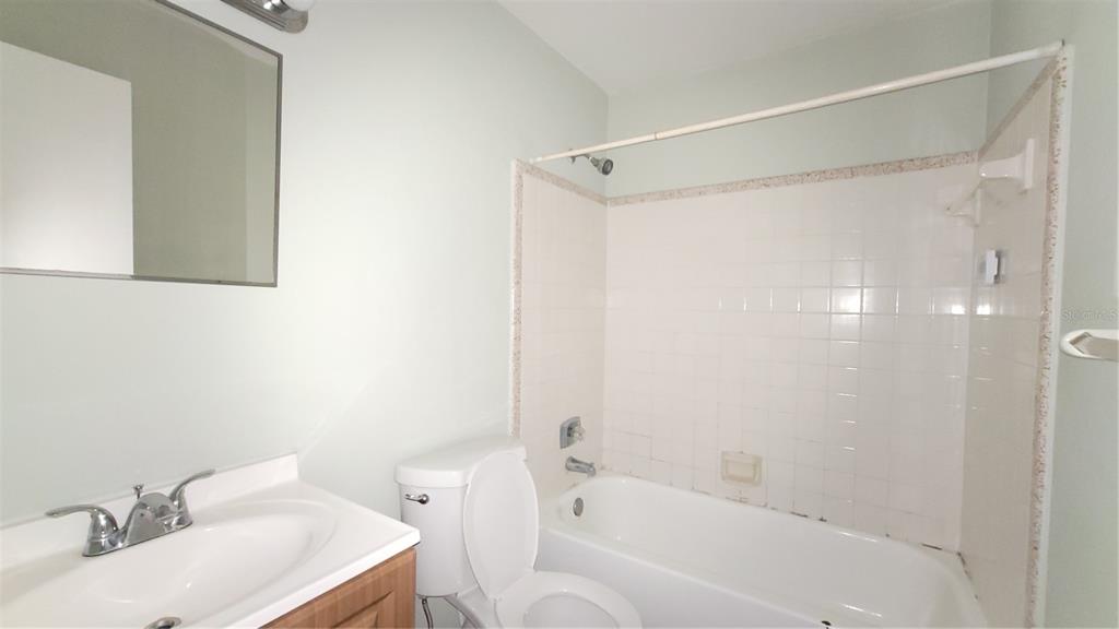 7119 Southwest 45th Place, Unit A Gainesville, FL 32608 - Photo 11 of 12 a white bath tub sitting next to a white sink and a shower