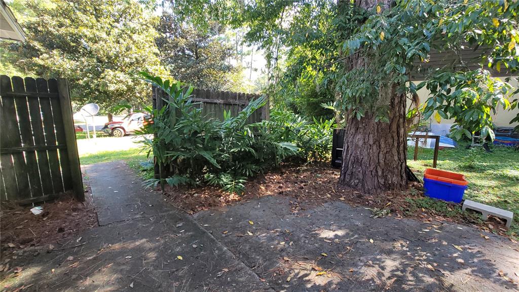 7119 Southwest 45th Place, Unit A Gainesville, FL 32608 - Photo 4 of 12 a view of a yard with plants and a trees