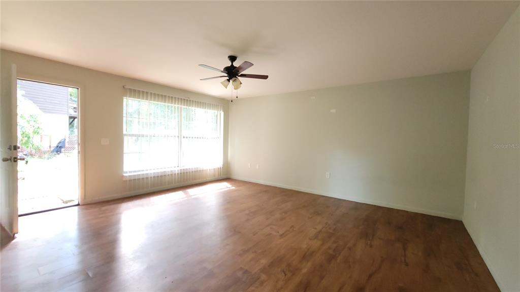 7119 Southwest 45th Place, Unit A Gainesville, FL 32608 - Photo 9 of 12 a view of empty room with wooden floor and fan