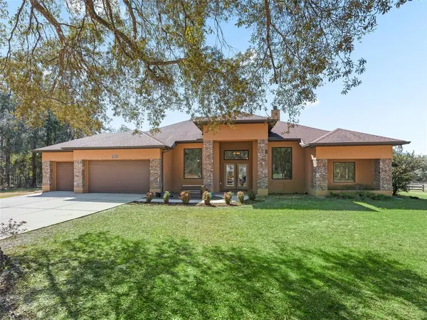 a front view of a house with a yard and trees