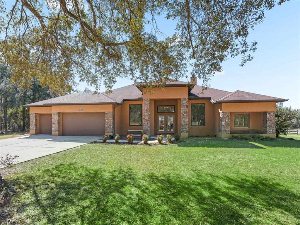a front view of a house with a yard and trees