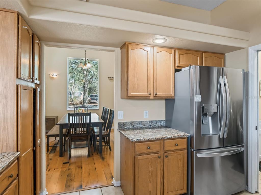 11670 Southeast 6th Street Williston, FL 32696 - Photo 17 of 63 a kitchen with granite countertop a refrigerator a table and chairs