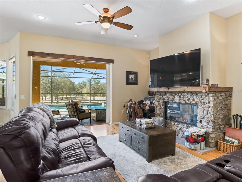 11670 Southeast 6th Street Williston, FL 32696 - Photo 6 of 63 a living room with furniture a fireplace and a flat screen tv