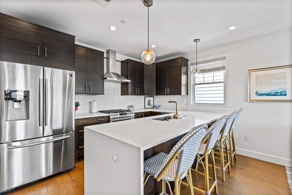 241 Lexington Street, Unit 2 Boston, MA 02128 - Photo 2 of 21 a kitchen with stainless steel appliances granite countertop a refrigerator a sink a stove a dining table and chairs