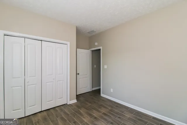 a view of an empty room with wooden floor