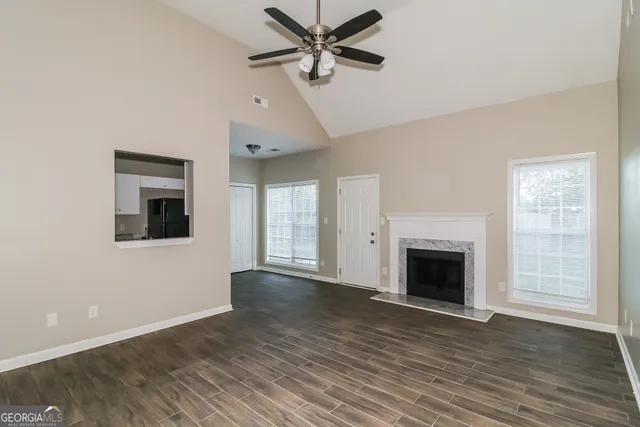 a view of a livingroom with a ceiling fan a fireplace and wooden floor