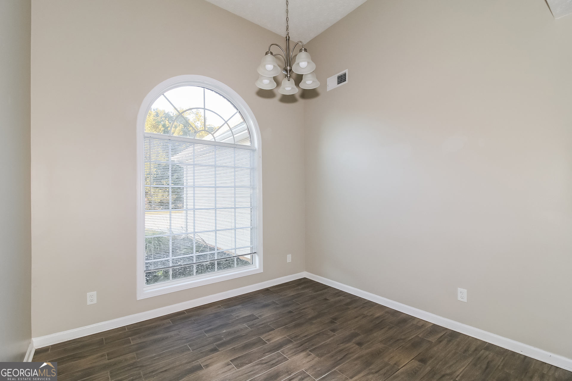 3399 Bells Landing Drive Rex, GA 30273 - Photo 5 of 16 an empty room with wooden floor chandelier and windows