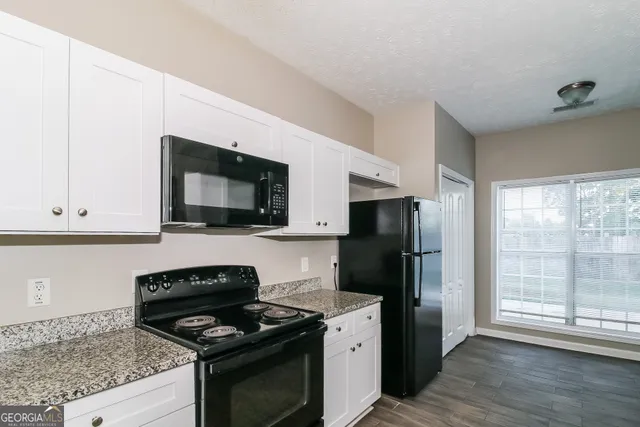 a kitchen with stainless steel appliances granite countertop a stove a refrigerator and a microwave