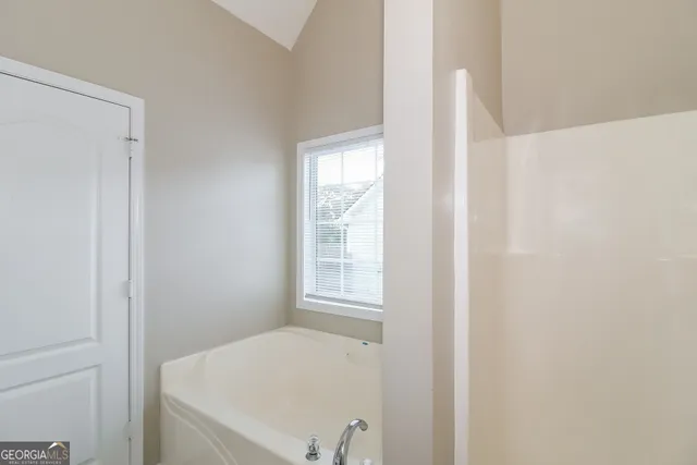 a bathroom with a bathtub and window