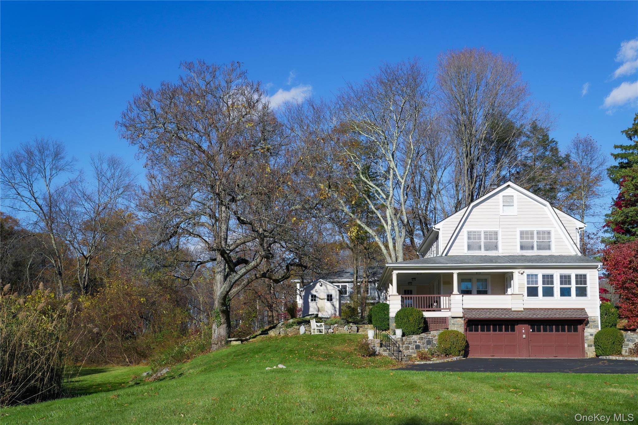 a front view of house with yard and trees in the background