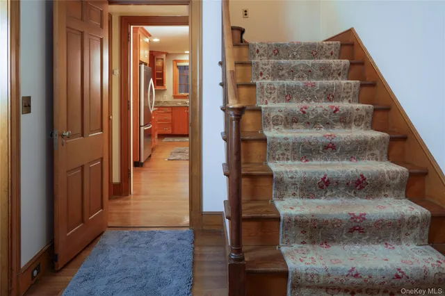 a view of a hallway with wooden floor and entryway