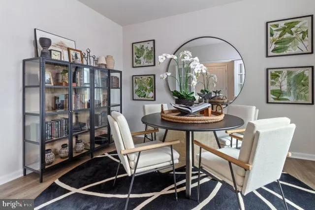 a dining room with furniture and wooden floor to ceiling window