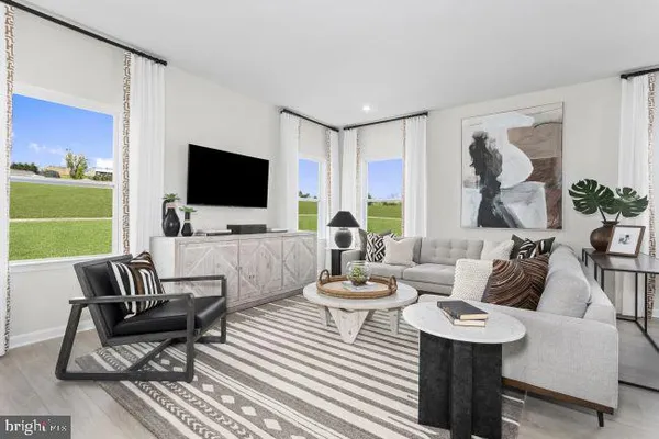 a living room with furniture a flat screen tv and a large window