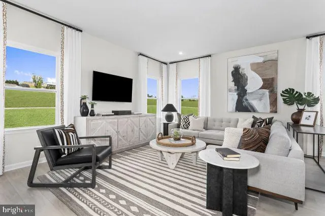 a living room with furniture a flat screen tv and a large window