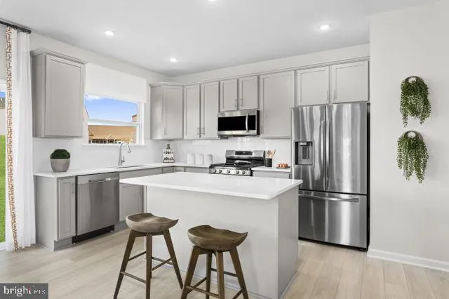 a kitchen with stainless steel appliances a refrigerator stove microwave and sink