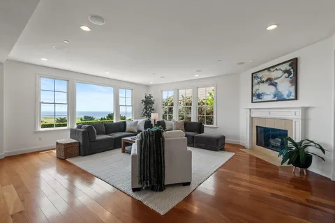 a large living room with stainless steel appliances granite countertop a sink and a large window