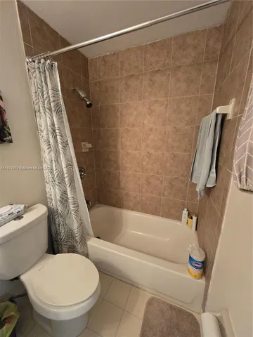 a white toilet sitting next to a bath tub and a shower