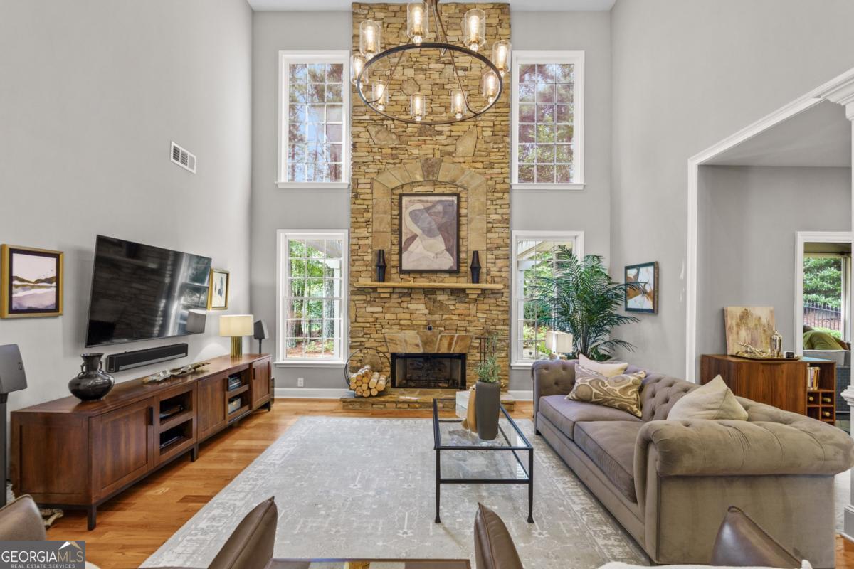 7029 Bennington Lane Cumming, GA 30041 - Photo 1 of 1 a living room with furniture a fireplace and a flat screen tv