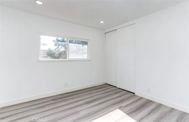 an empty room with wooden floor and window