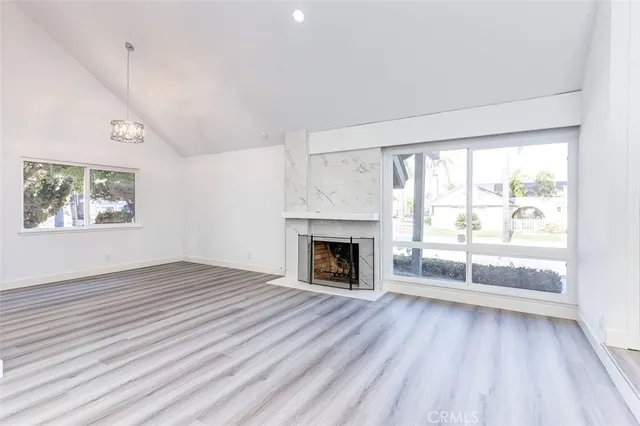 wooden floor fireplace and windows in an empty room
