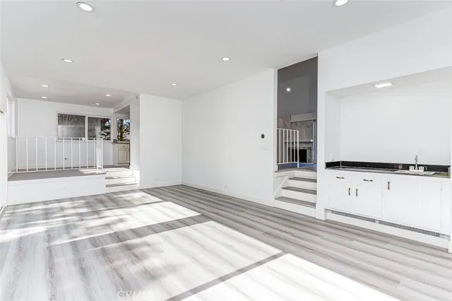 a view of a kitchen with kitchen island a sink stainless steel appliances counter space and a window