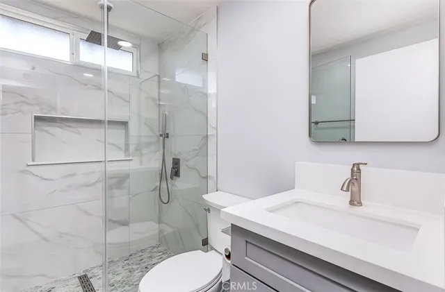 a bathroom with a sink a toilet and shower